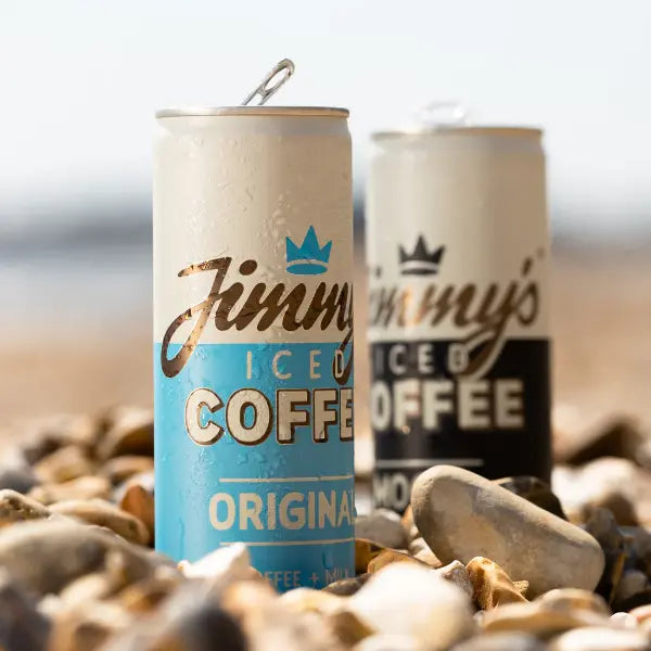 Jimmy's Iced Coffee Original SlimCan 250ml and Jimmy's Iced Coffee Mocha SlimCan 250ml on some rocks in the beach