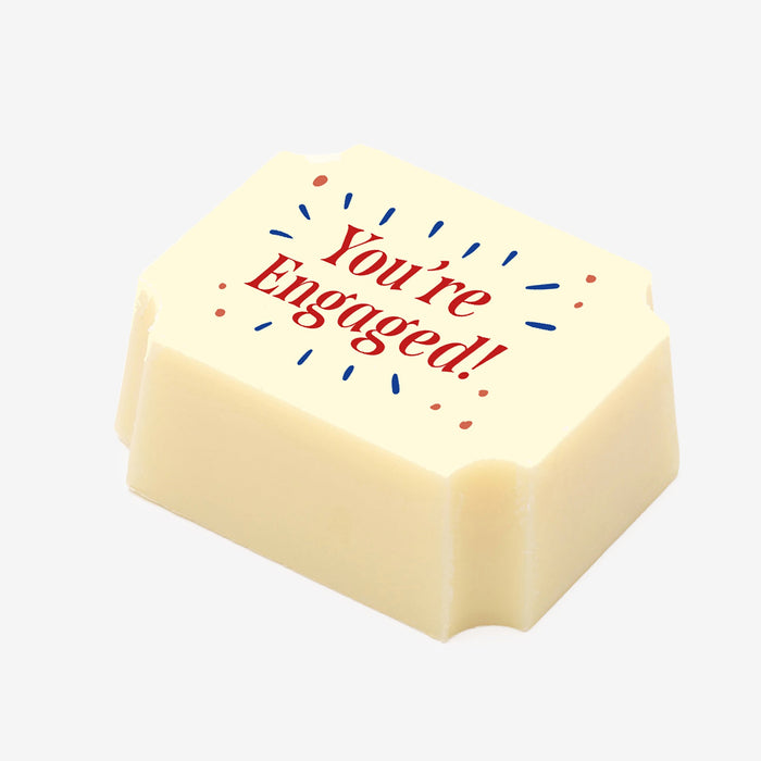 A white chocolate filled with dark chocolate ganache, made by Harry Specters, with a You're Engaged message printed on the top.