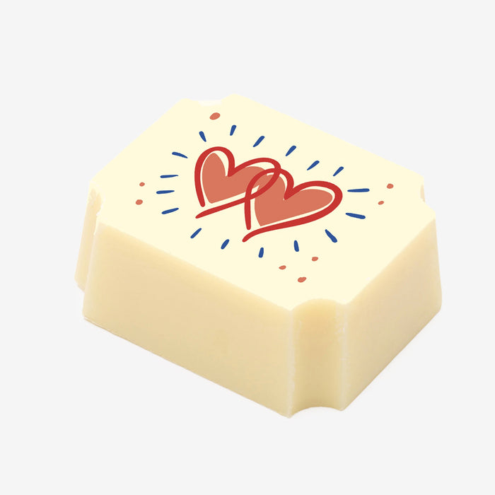 A white chocolate filled with dark chocolate ganache, made by Harry Specters, with an Engagement themed heart image printed on the top.