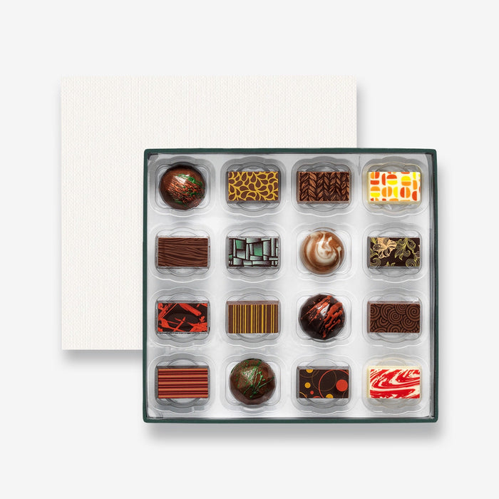 An open chocolate selection box containing 16 chocolates made by Harry Specters. The chocolates seen within this gift box are a colourful mix of white, milk, and dark chocolate.