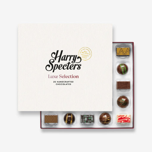 A chocolate selection box containing 25 chocolates, partially covered by a lid showing the name Harry Specters. The chocolates seen within this gift box are a colourful mix of white, milk, and dark chocolate with two Engagement message chocolates.